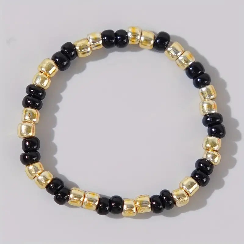 Affordable Confettis ring by Leopoldine in glossy black and gold-tone beads, stylish stackable accessory under £10 – a sleek statement for UK fashion lovers.