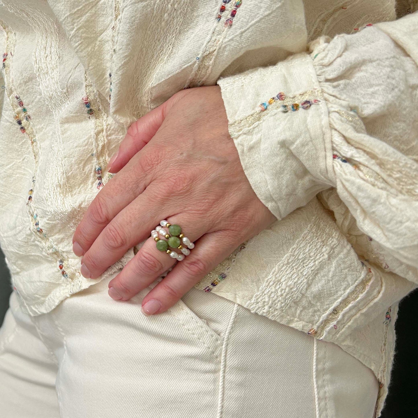 Affordable green jade and pearl rings by Leopoldine, stylish gold-tone trio stack on hand, elegant UK fashion jewellery.