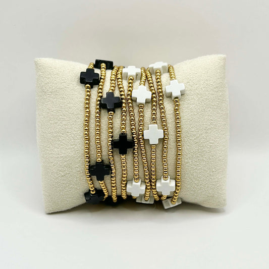 Stylish stack of Divine cross bracelets in black and white with gold beading – handmade jewellery designed for layering, perfect for gifting in the UK.