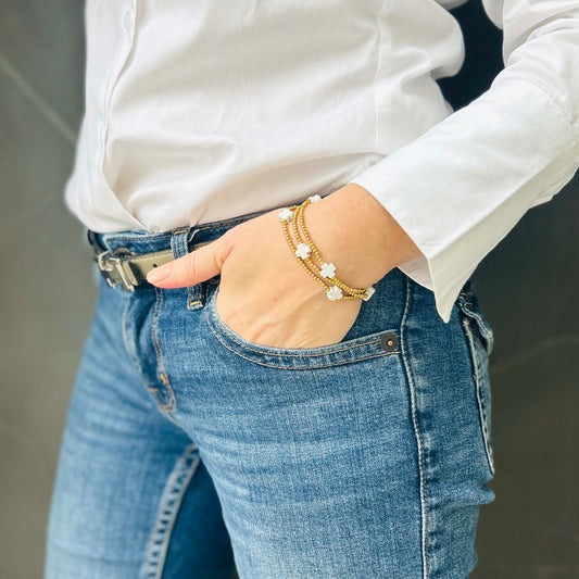 Minimalist gold and white cross bracelet on wrist – Leopoldine Divine bracelet featuring delicate beaded strands and elegant cross-shaped white stones.