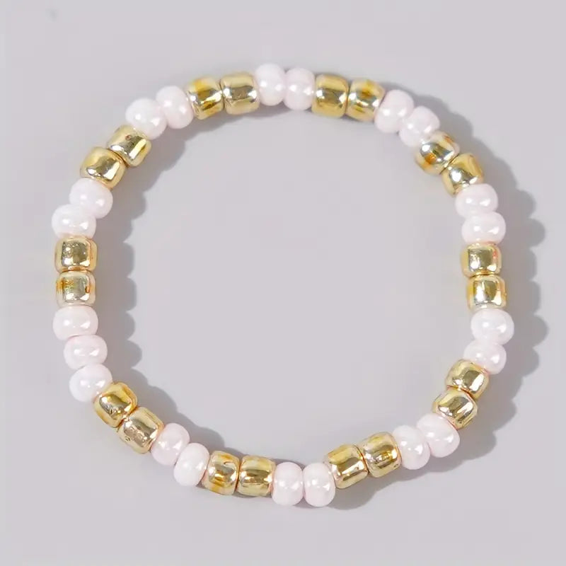 Affordable white and gold Confettis ring by Leopoldine, featuring glossy glass beads in a playful stackable design – stylish and under £10, photographed against a soft grey background.