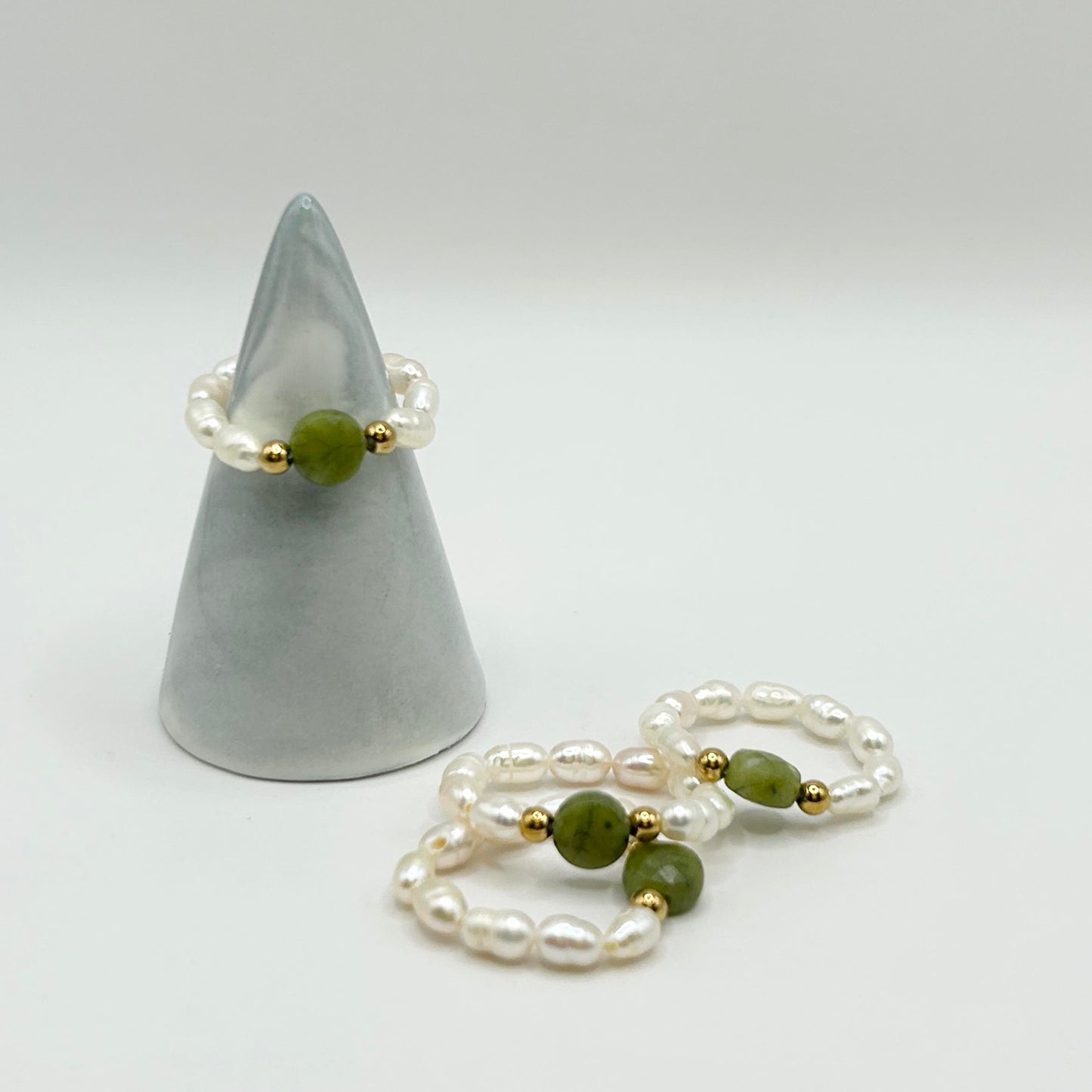 Affordable Leopoldine Amity ring with green jade centre and pearl-style beads, displayed on ring holder – elegant UK jewellery gift under £15.
