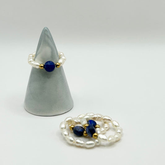 Affordable Leopoldine Amity ring with deep blue lapis lazuli and pearl-style beads, styled on soft display cone – elegant stackable jewellery under £15 UK.