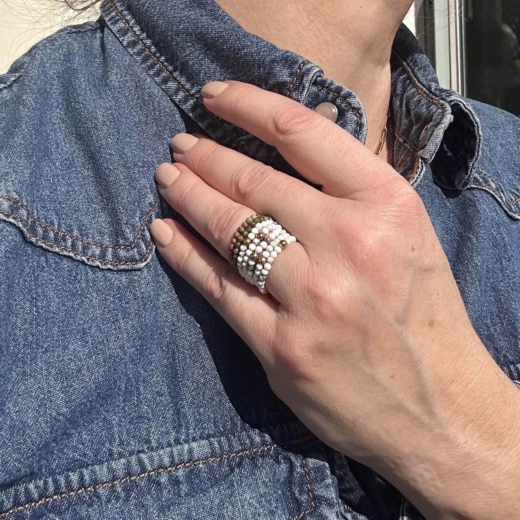 Aurora adjustable beaded rings stacked in white, gold and green – affordable stretch rings for women, stylish and stackable jewellery UK