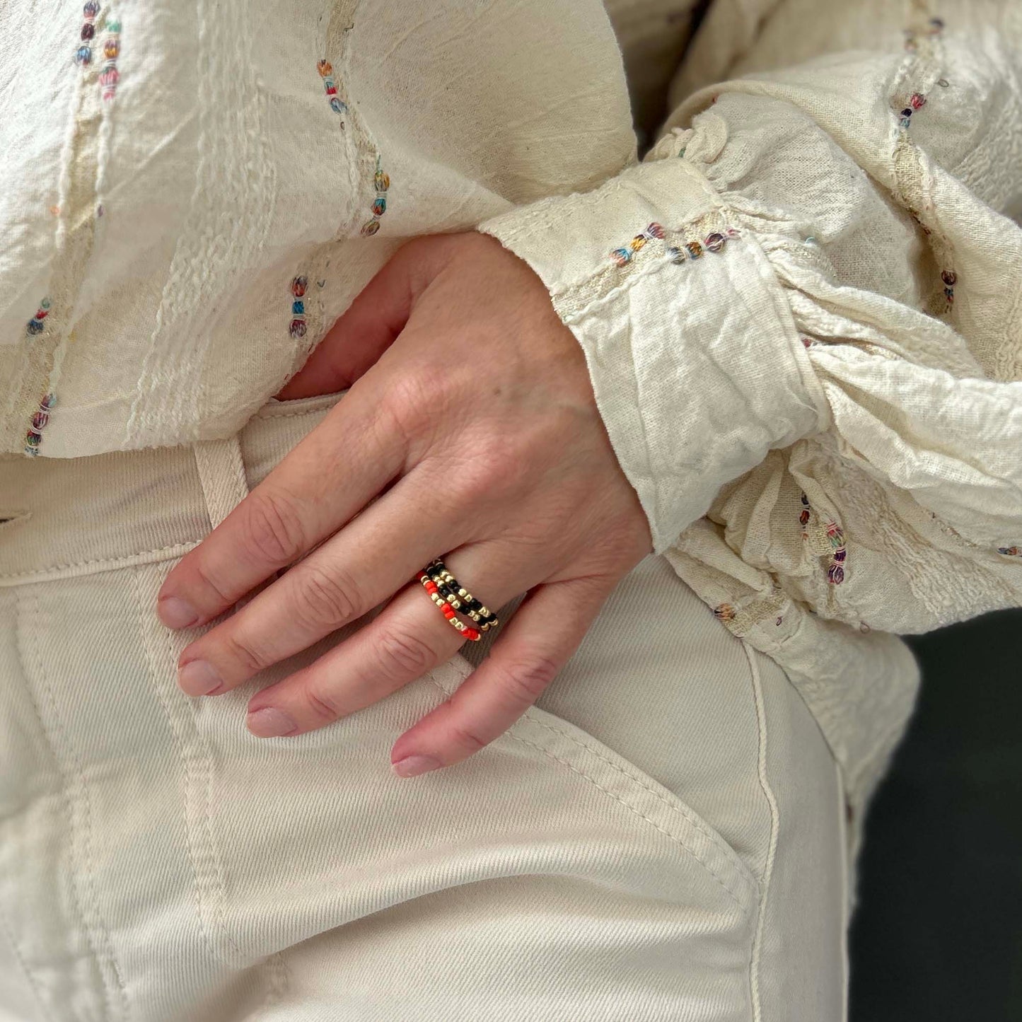 Leopoldine Confettis ring set in black, red and gold-tone beads — a bold, stackable trio made from colourful glass, perfect for UK jewellery lovers.