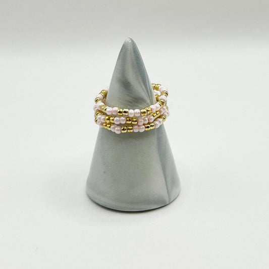 Leopoldine Confettis baby pink and gold beaded rings, affordable stackable style under £10, shown on display cone.