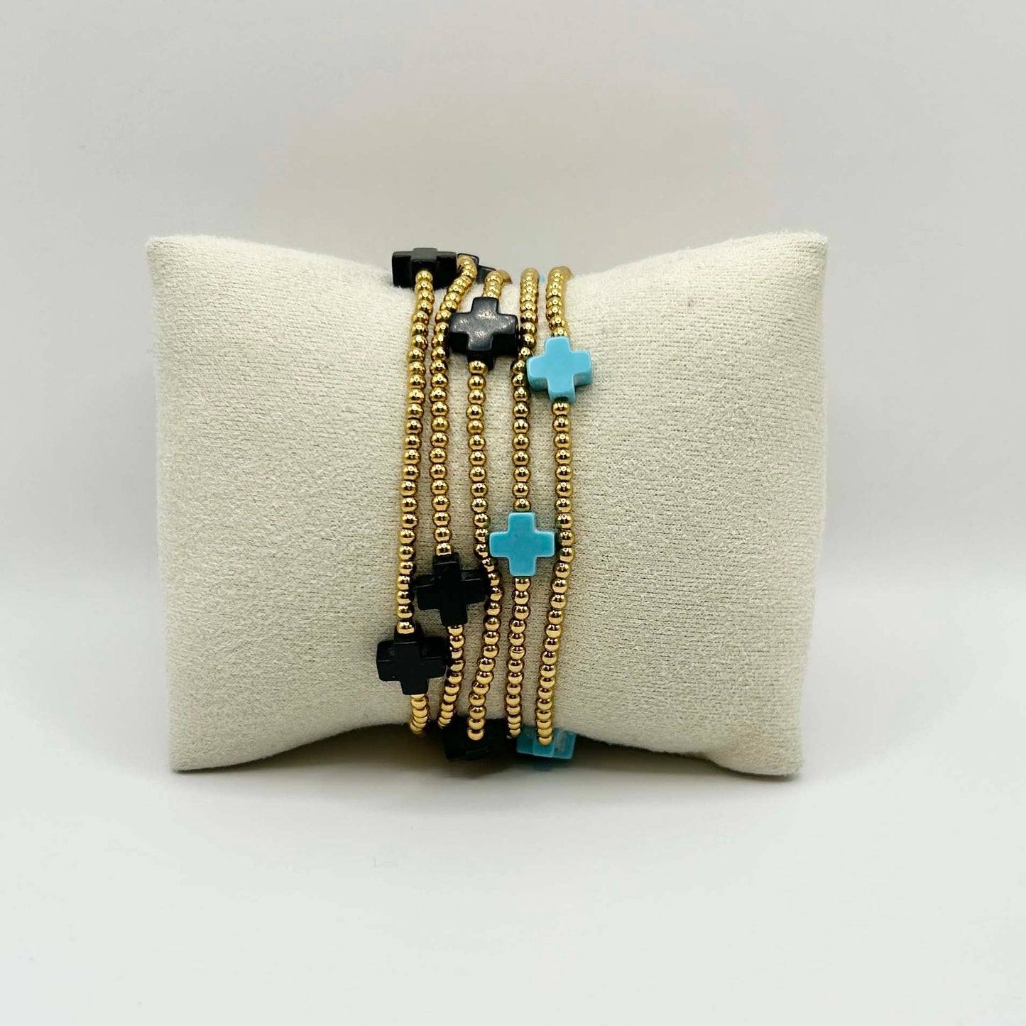 Gold stacking bracelet set with bold turquoise and black cross beads – an eye-catching, affordable jewellery combo from Leopoldine, perfect for layering and gifting in the UK.
