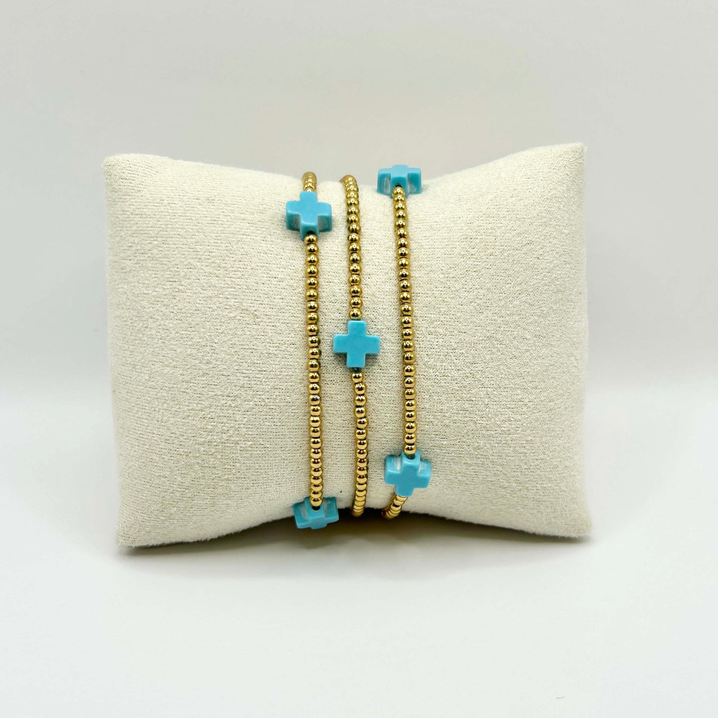 Leopoldine Divine bracelet with trio of turquoise cross beads and gold stainless steel accents – fun, spiritual, and colourful stacking piece, ideal affordable gift made for sunshine lovers in the UK.