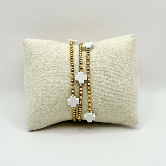Leopoldine Divine bracelet with five white cross beads and golden stainless steel accents – chic, minimalist jewellery perfect for stacking and gifting in the UK.