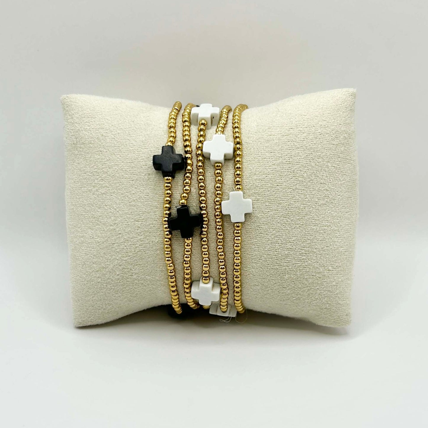 Stylish stack of black and white cross bracelets with gold beads – a versatile, affordable jewellery set for effortless everyday elegance.