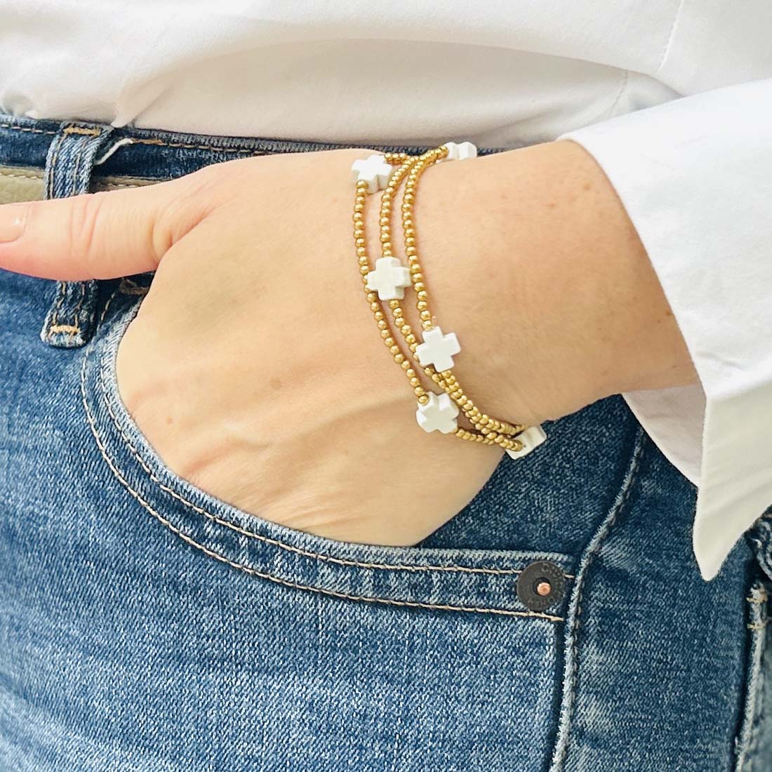 Close-up of the Leopoldine Divine bracelet with white cross stones and gold beaded strands – modern and delicate wrist accessory for everyday elegance.