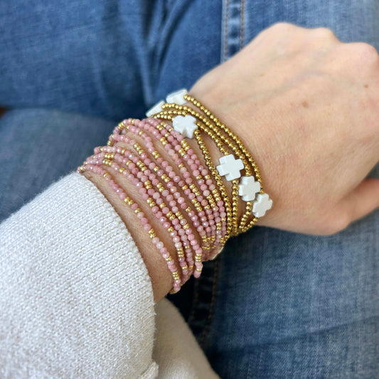 Pink Selene beaded bracelet stack with Divine white cross bracelet – affordable layered jewellery with soft tones