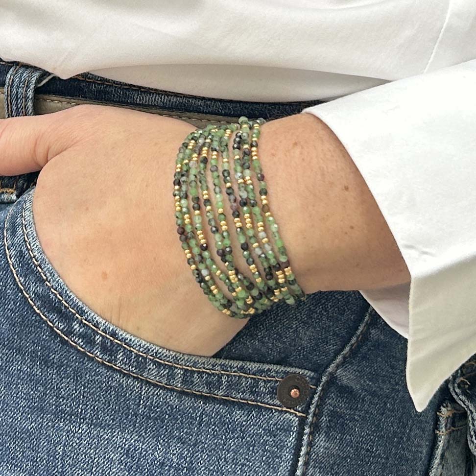 Zoom on Leopoldine Selene bracelet – layered strands of delicate green and gold glass beads wrapped around the wrist, handmade bohemian jewellery.